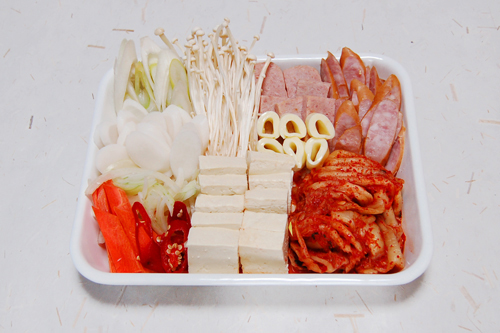 キムチと豆腐は一口大に、ソーセージとランチョンミート、長ねぎ、韓国唐辛子は斜め切り。玉ねぎは薄切り、人参は短冊切りにする。エノキダケは石づきを落とす。チーズは巻いてから1cm幅に切る。