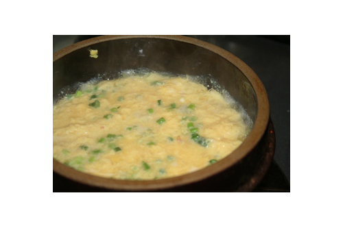 土鍋にだし汁を入れて中火にかけ、煮立ったところに（2）を少しずつ入れる。全部入れたら焦げないようにスプーンで1～2回、底からやさしく混ぜ、表面をスプーンの底などで平らに整えて蓋をする。