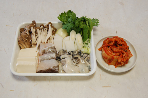 キムチ、豆腐は一口大、鱈は三等分に切る。玉ねぎは2cm幅、長ねぎは3cm分は斜め切り、残りは小口切りにする。大根は短冊切り、春菊は半分に切る。しめじ、舞茸は石づきを落としてほぐす。