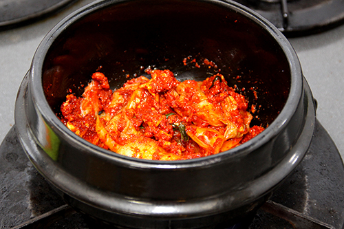 トゥッペギ（または土鍋）に、キムチと玉ねぎ、Aを入れて混ぜあわせ10分ほどおいてから、鍋を中火にかける。鍋が温まったら弱火にして、焦げないように注意しながら3分ほど炒める。
