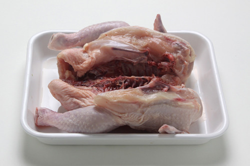 鶏肉はきれいに洗って尾の部分を切り落とし、お腹に包丁を入れて開く。