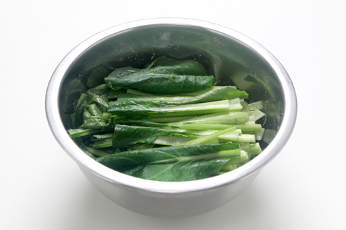 ボールに長さ10cmほどに切った小松菜と塩を入れ、しっかりと混ぜあわせて15分ほどおく。