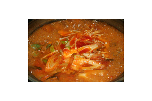 （4）に豆腐をスプーンですくって入れ、（2）の野菜ときのこ、アミの塩辛を加えて3分ほど煮る。

